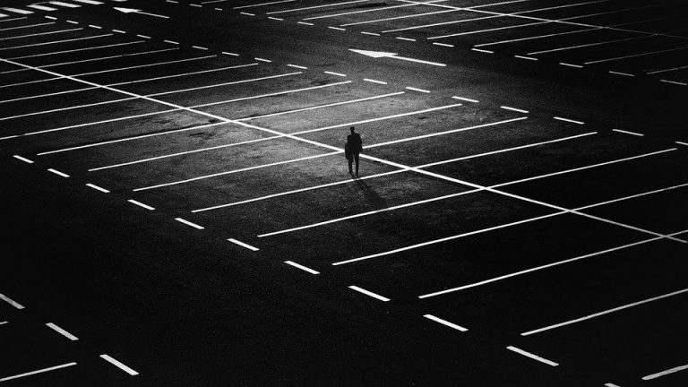 person walking on an empty parking lot