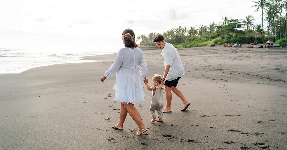 young family walking on a sandy beach
