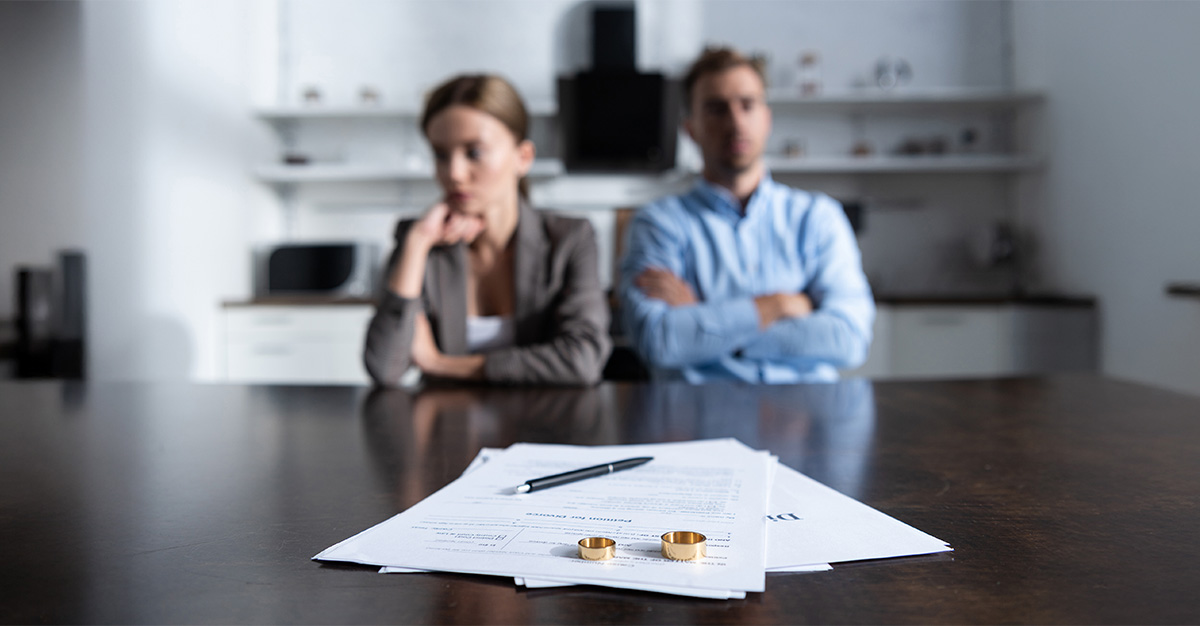 couple sitting at table with divorce documents