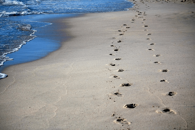 two sets of footprints on the beach