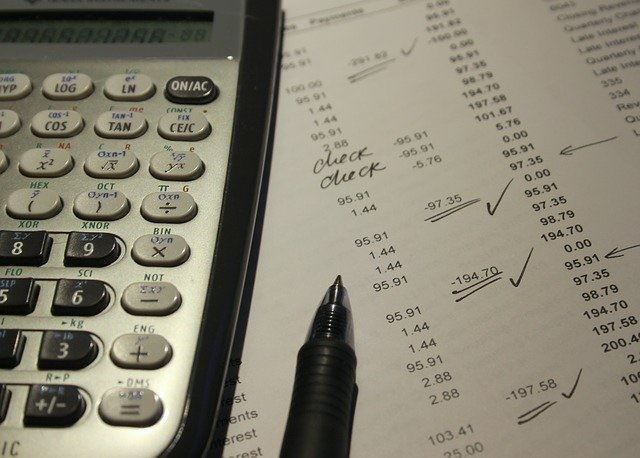calculator, pen and bills